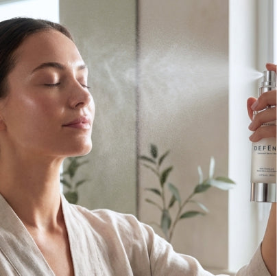 Applying DEFEND ceramide barrier mist evenly across face and neck